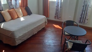 A room with a bed, a table, and chairs. - Chillinn at Duke (Kingston)