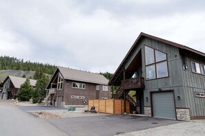 Een modern gebouw met twee verdiepingen, een grote garage en een overdekte veranda.