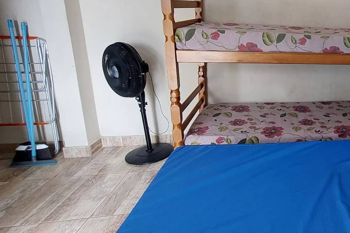 A bunk bed with a floral-patterned top bunk and a blue bottom bunk.