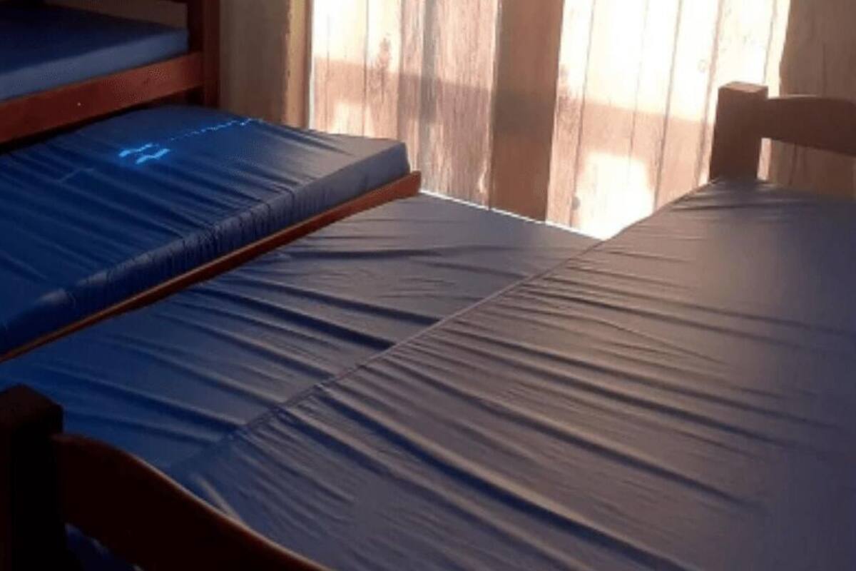 A bunk bed with blue mattresses in a room with a tiled floor.