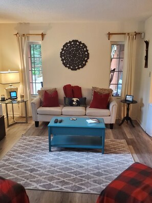 Relax in this inviting living room with a comfortable sofa, coffee table, and decorative wall piece.