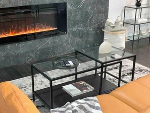 Cozy up by the fireplace in this stylish living room, featuring a leather sofa and a patterned rug.