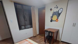 Une chambre avec un lit, un bureau et une armoire.