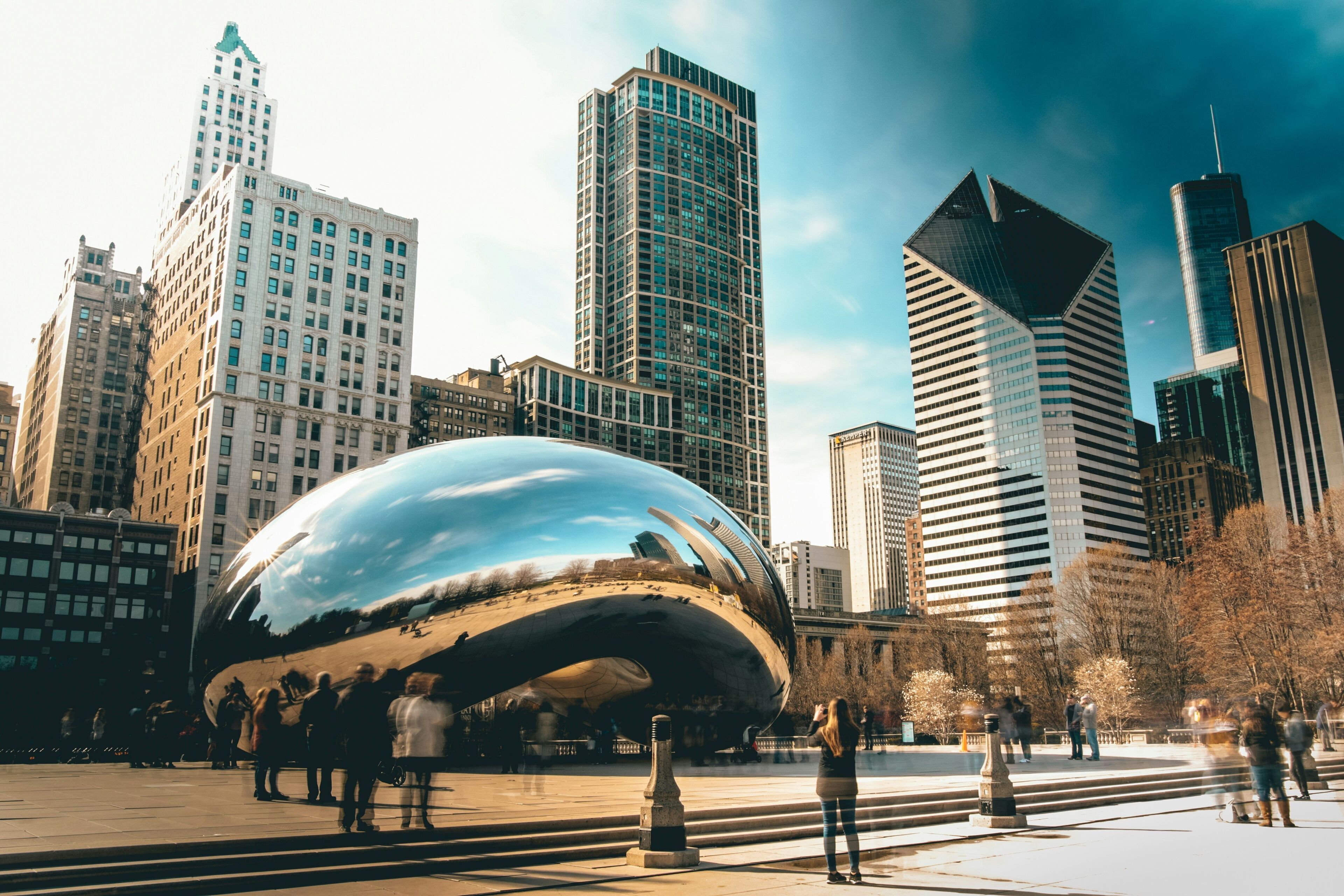 A modern cityscape with a prominent spherical sculpture in the foreground, surrounded by high-rise buildings.
