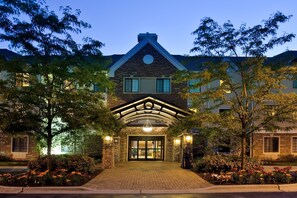 A large, two-story building with a stone facade, a prominent entrance with a glass door, and a landscaped garden with flowering plants. - 1 Bedroom | Free Breakfast, Indoor Pool Access (Lincolnshire)