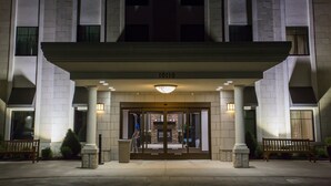 L’entrée d’un hôtel, avec un large auvent, des colonnes et une enseigne indiquant « 1010 ».
