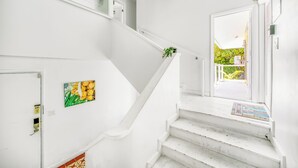 A white staircase with a glass door at the top leading to a bright room. - Charming 3 Bedroom Suite 200 steps to Beach, car available (Freeport)
