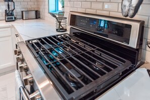 Une cuisine équipée d’une cuisinière en acier inoxydable, d’un grille-pain et d’un four à micro-ondes.