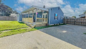 Einbungalow mit überdachter Veranda und einem umzäunten Garten.