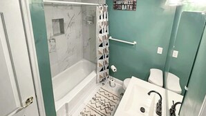 Ein Badezimmer mit einer Badewanne, einer Dusche, einer Toilette und einem Waschbecken.