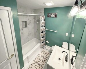 Ein Badezimmer mit einer Badewanne, einer Dusche, einer Toilette und einem Waschbecken.