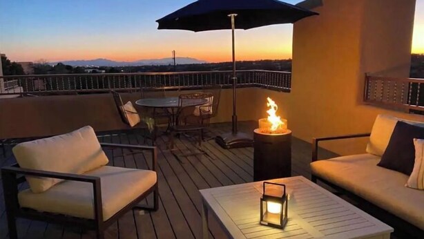 Una terraza con mobiliario exterior, una mesa y una chimenea.