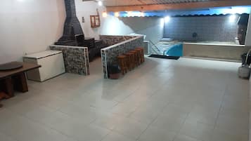 Um espaço amplo e interno com cozinha, sala de jantar e piscina.