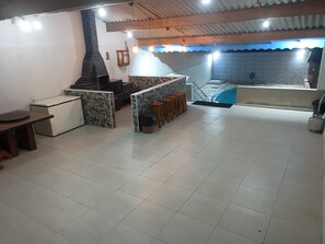 Un grand espace intérieur comprenant une cuisine, un coin repas et une piscine.