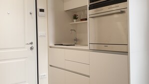 A modern kitchen with white cabinetry, a built-in oven, and a microwave. - Exclusive suite in the historic center (Bologna)