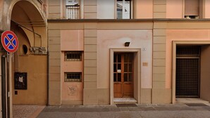 A building with a no parking sign, a door with a number plate, and a barred window. - Exclusive suite in the historic center (Bologna)
