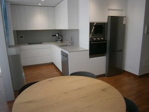 A compact kitchen with white cabinets, a built-in oven, and a refrigerator. - "Xot" 1bedroom+Sofa-bed 2/4 peoples, Streetview, centre village (Sant Carles De La Rapita)