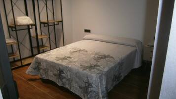 Un dormitorio con cama, armario y estantería.