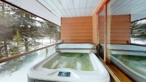 A hot tub on a balcony with a view of snow-covered trees. - Lakefront Suite w/ Private Hot Tub | Fireplace (Naramata)