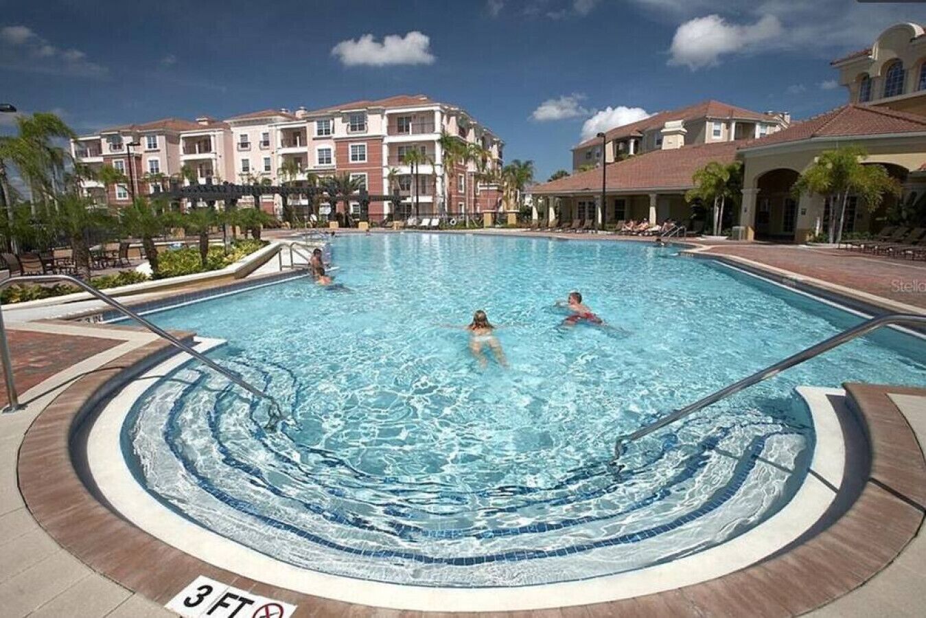 A swimming pool with a 3ft depth marker, surrounded by a pool deck and palm trees.