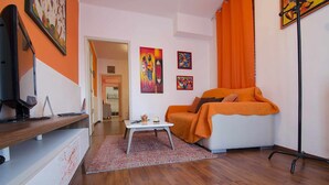 Een moderne woonkamer met een bank, salontafel en kunstwerken aan de wanden.