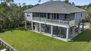 Une maison à deux étages dotée d’un patio couvert et d’un escalier menant à l’étage supérieur.