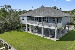 A two-story house with a covered patio and a staircase leading to the upper level. - Waterfront Retreat! Fish, Boat & Relax (Bay St. Louis)
