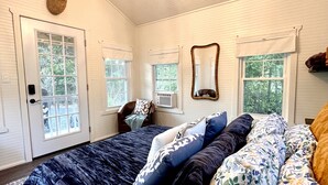 Une chambre à coucher avec un grand lit, un lustre, une décoration représentant une tête de cerf et un miroir au mur.