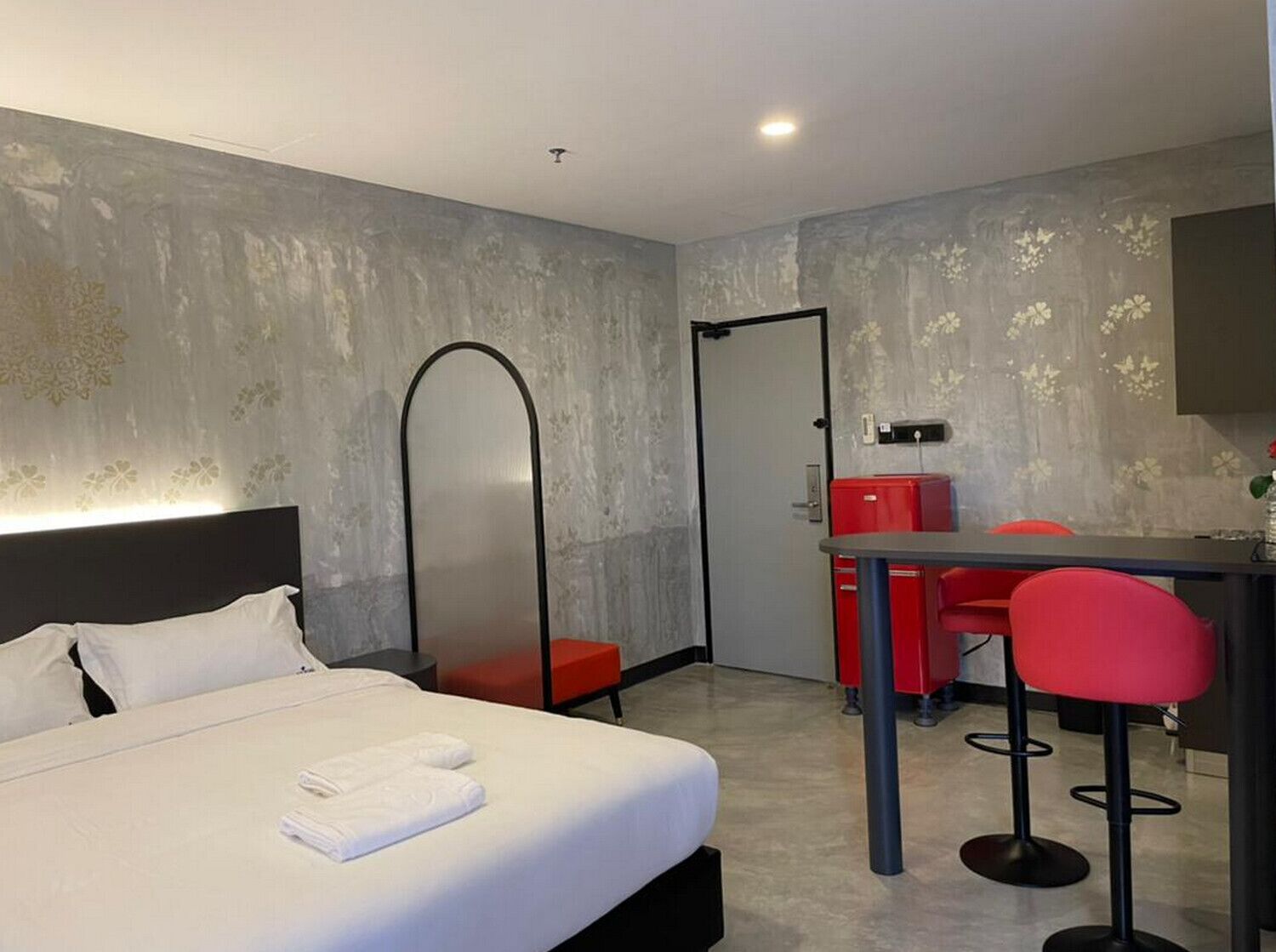 A hotel room with a bed, a desk, and a chair.