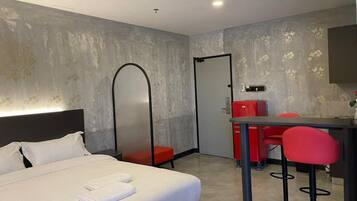 A hotel room with a bed, a desk, and a chair.