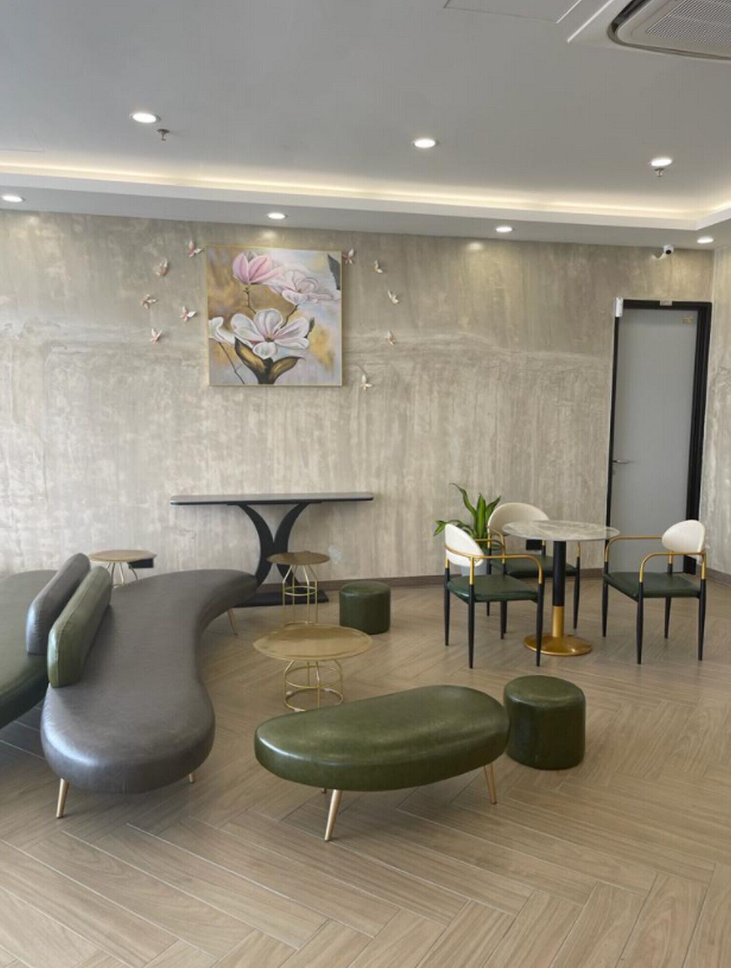 Un espace de détente moderne avec un canapé incurvé, des tables rondes et des fauteuils.