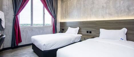 Habitación de hotel con dos camas, un ventanal con cortinas, pared de concreto y un cabecero moderno.