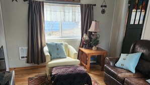A cozy living room with a beige sofa, a brown leather couch, and a patterned rug. - Shady Rest in Hot Springs MT. (Hot Springs)
