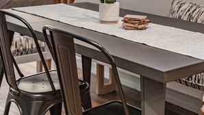 Un coin repas avec un escalier en bois en arrière-plan.