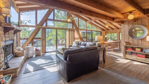 A spacious living room with a fireplace, leather sofa, and a dining area with wooden furniture. - The Firefly Inn by Innsbrook Vacations! (Innsbrook)