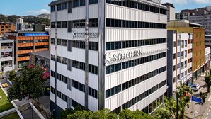 A modern hotel with a prominent 'SOJOURN' sign, multiple floors, and a mix of window styles.