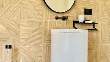 A bathroom with a large white sink, a mirror, and a wooden patterned wall.