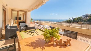 Un balcon équipé d’une table de billard, de fauteuils et offrant une vue sur la mer.