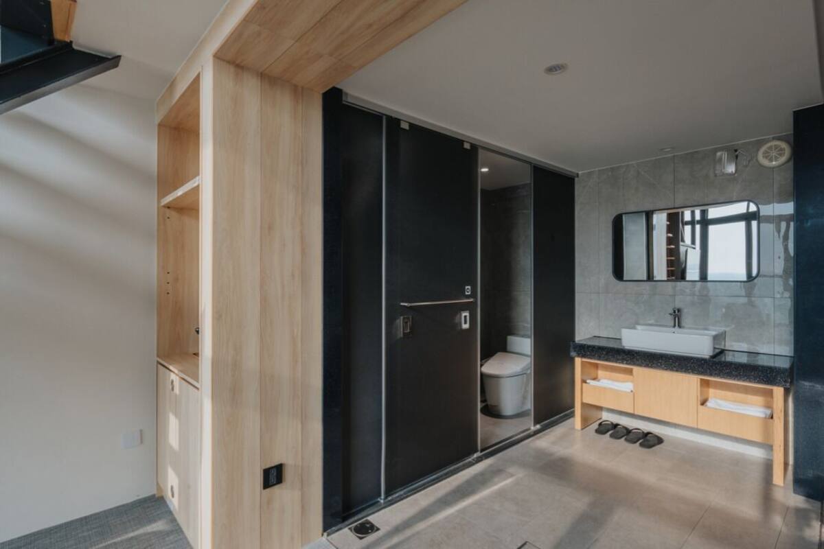 A modern bathroom with a glass shower enclosure, a large mirror, and a built-in sink with a vanity.