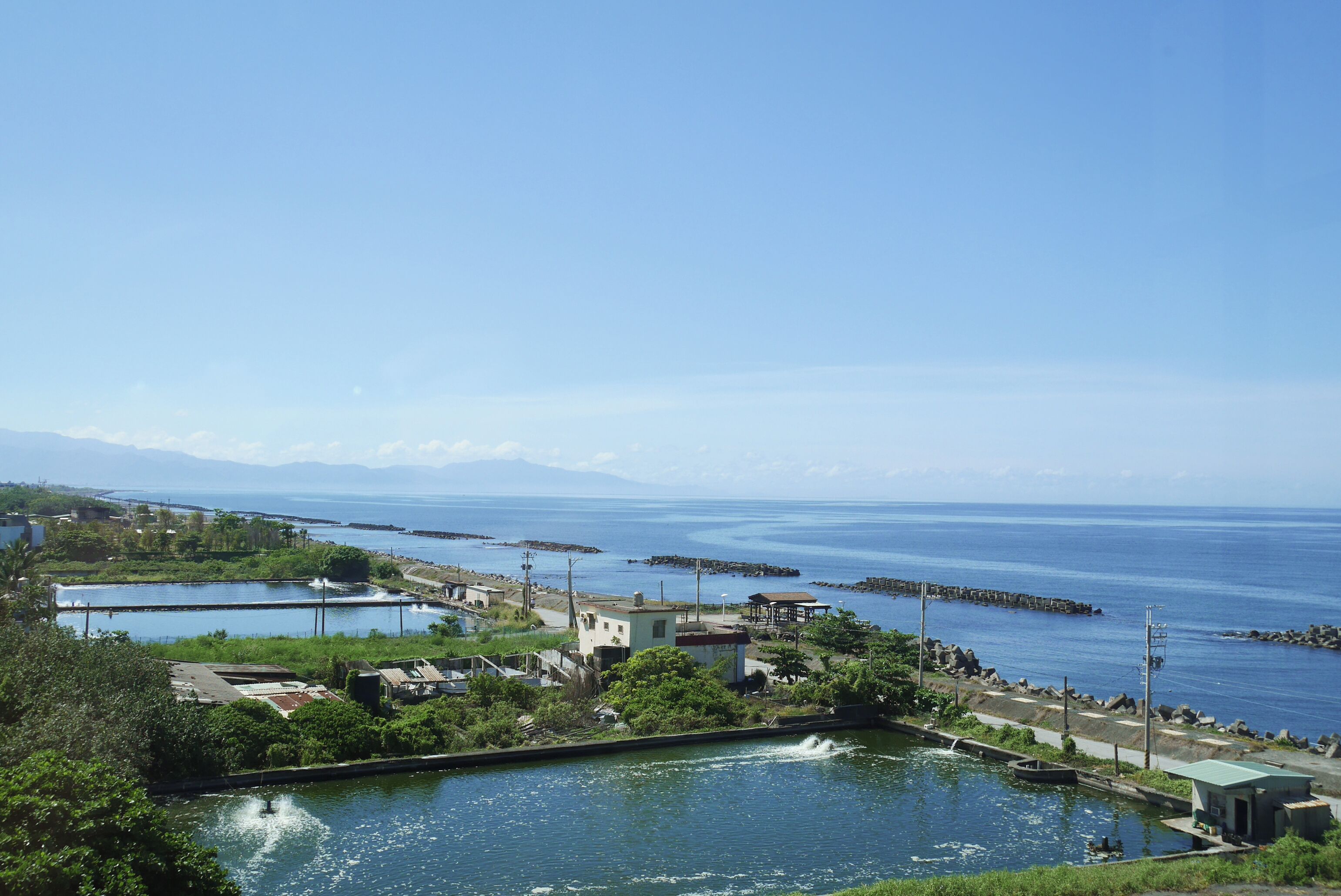 Una zona costera con un puerto deportivo, barcos y edificios cerca del agua.