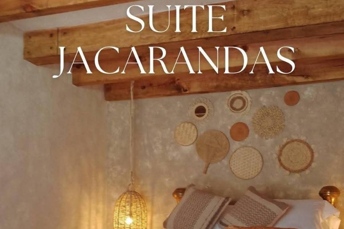 Uma cama com estrutura de latão, cabeceira trançada e tapete estampado.