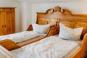 A room with two wooden beds, each with a headboard and matching pillows.