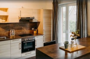 Uma cozinha moderna com forno embutido, pia de aço inoxidável e armários de madeira.