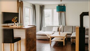 Un salon moderne avec un canapé, une table basse et un téléviseur.