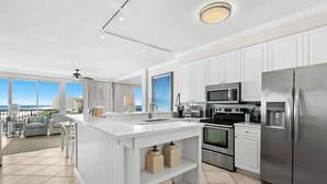 A modern kitchen with white cabinetry, stainless steel appliances, and a large island. - Relaxing Miramar Beach Retreat With Sunset Gulf Views (Miramar Beach)