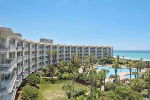 A hotel with multiple balconies, a pool area, and a view of the ocean. - Gulf-Front Family Retreat Sleeps 10 with Pool and Hot Tub (Miramar Beach)