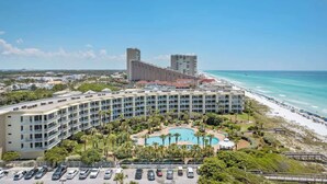 A hotel with a pool, beachfront view, and multiple buildings.