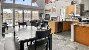 Una cocina moderna con comedor, ventanas amplias y vistas al exterior.