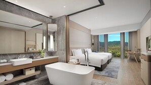 A modern hotel bathroom with a freestanding bathtub, a large mirror, and a vanity with a sink. - NBICC Wonderland Hotel (Ningbo)