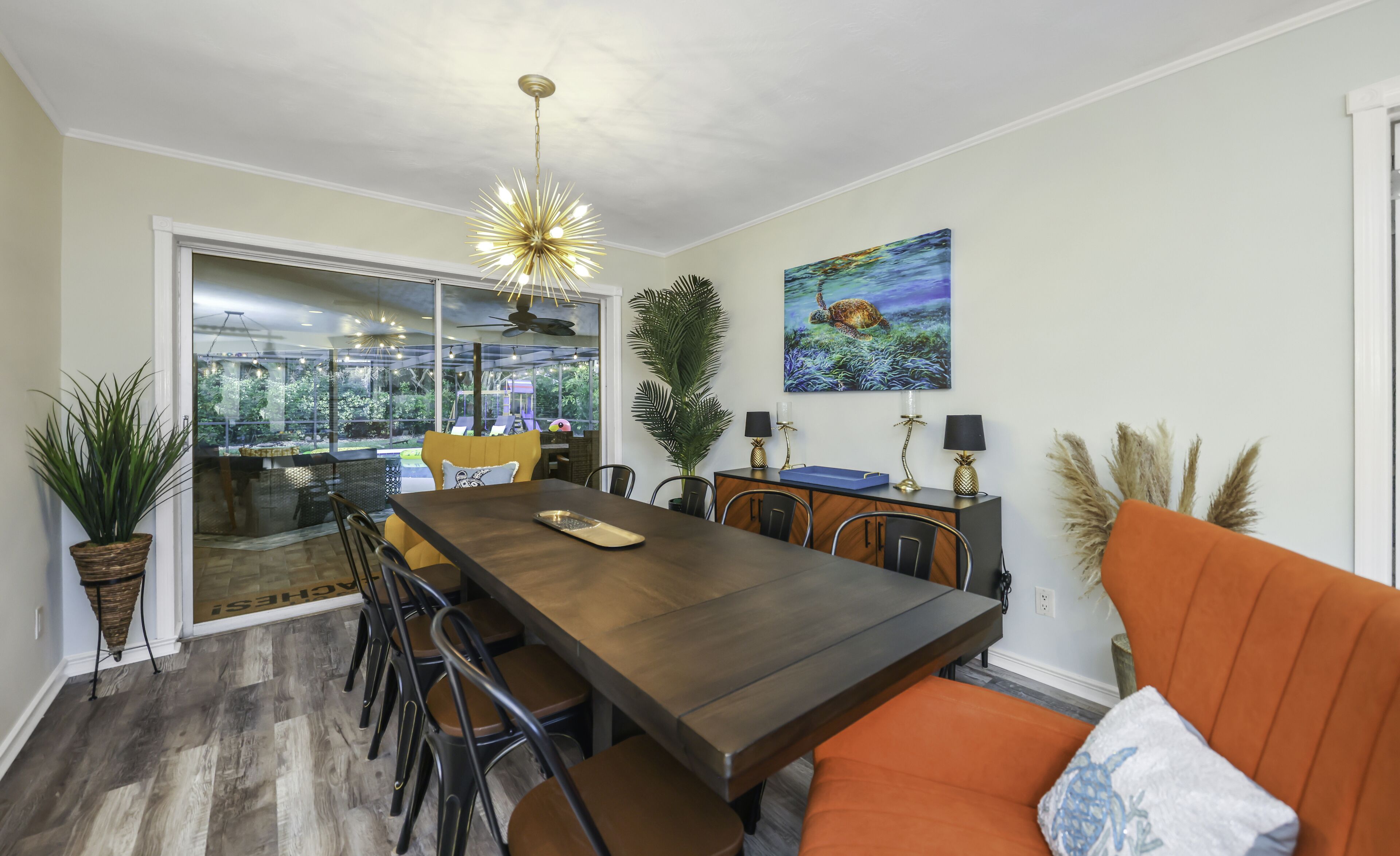 Un comedor con una gran mesa de madera, varias sillas y una lámpara moderna.
